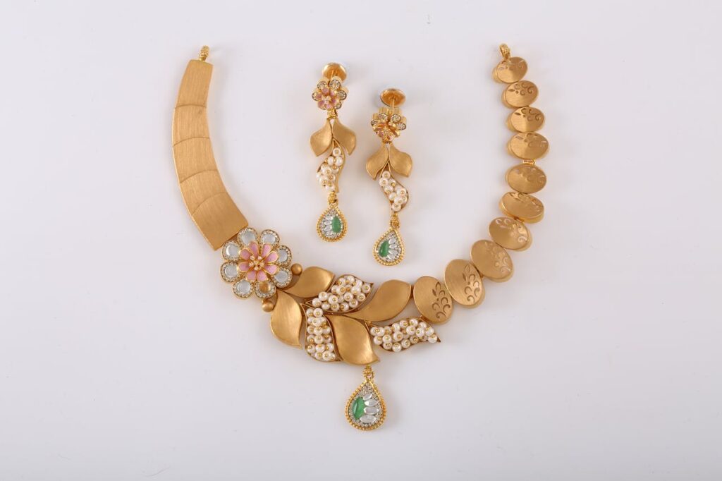 Sophisticated gold necklace set with floral patterns and gemstone embellishments, perfect for special occasions.
